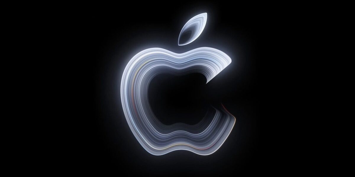 Apple'ın Pro and Tell davetiyesindeki resmi görsel: siyah zemin üzerinde gümüş tonlarında parlayan Apple logosu
