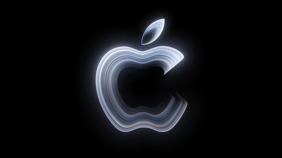 Apple'ın Pro and Tell davetiyesindeki resmi görsel: siyah zemin üzerinde gümüş tonlarında parlayan Apple logosu