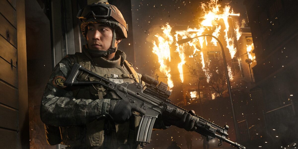 Call of Duty: Modern Warfare 4'ün resmi oyun içi görseli: elinde tüfekle yanan bir binanın önünde duran asker