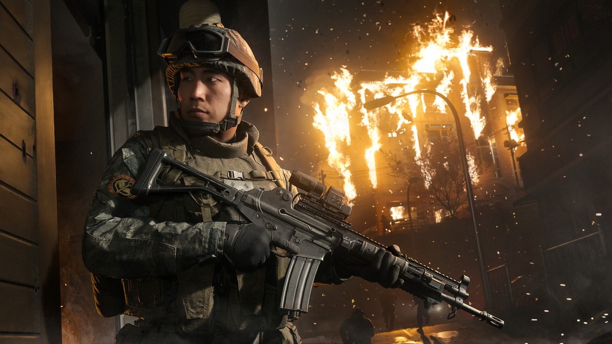 Call of Duty: Modern Warfare 4'ün resmi oyun içi görseli: elinde tüfekle yanan bir binanın önünde duran asker