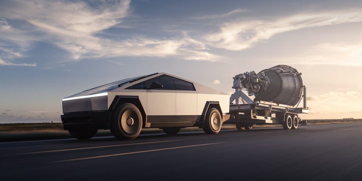 Tesla'nın resmi Cybertruck görseli: gün batımında asfalt yolda römork çeken gümüş renkli Cybertruck