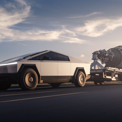 Tesla'nın resmi Cybertruck görseli: gün batımında asfalt yolda römork çeken gümüş renkli Cybertruck