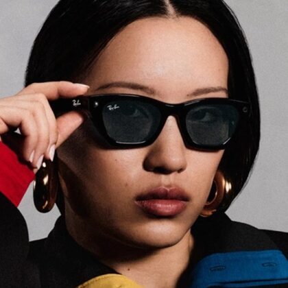 Meta'nın resmi tanıtım görseli: Ray-Ban Meta akıllı gözlük takan bir kadın gözlüğünü eliyle tutuyor