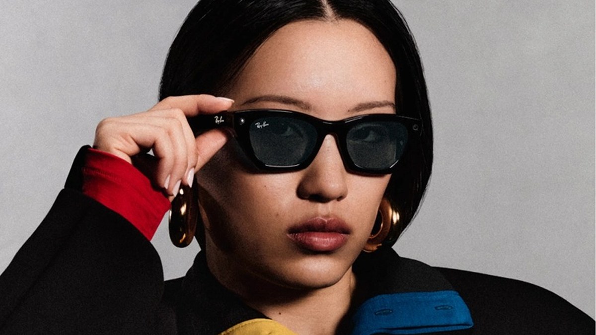 Meta'nın resmi tanıtım görseli: Ray-Ban Meta akıllı gözlük takan bir kadın gözlüğünü eliyle tutuyor